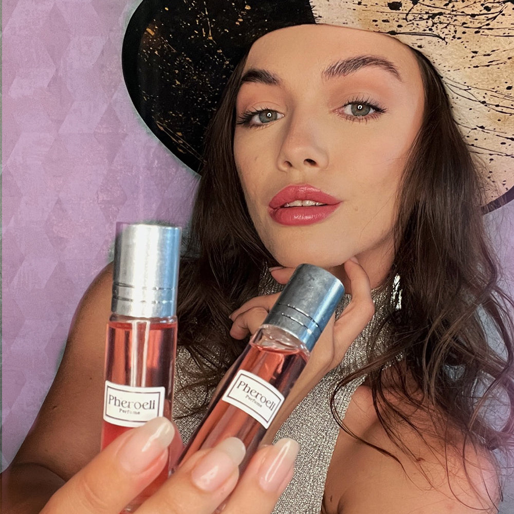 Mujer sosteniendo dos frascos de perfume Pheroeli